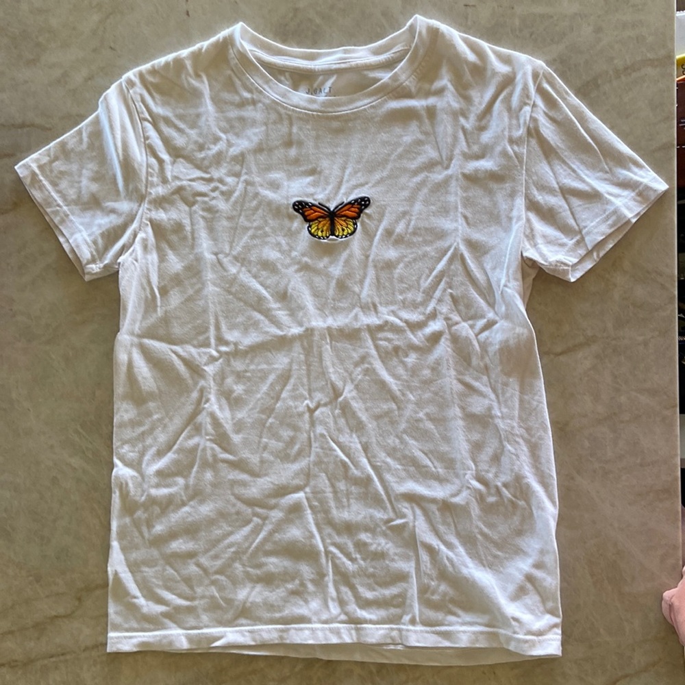 T-shirt with butterfly image stitched on front.
